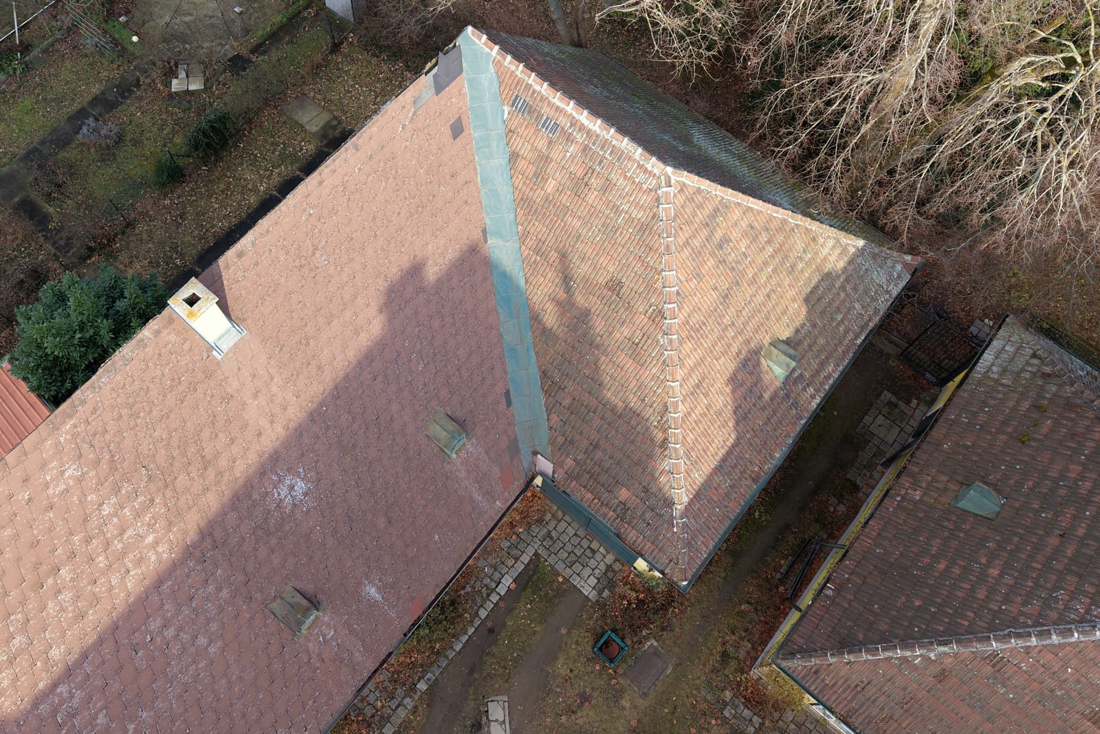 Dachflächen eines Vierkanthofs aus der Luft, Grat und Kaminkopf sichtbar